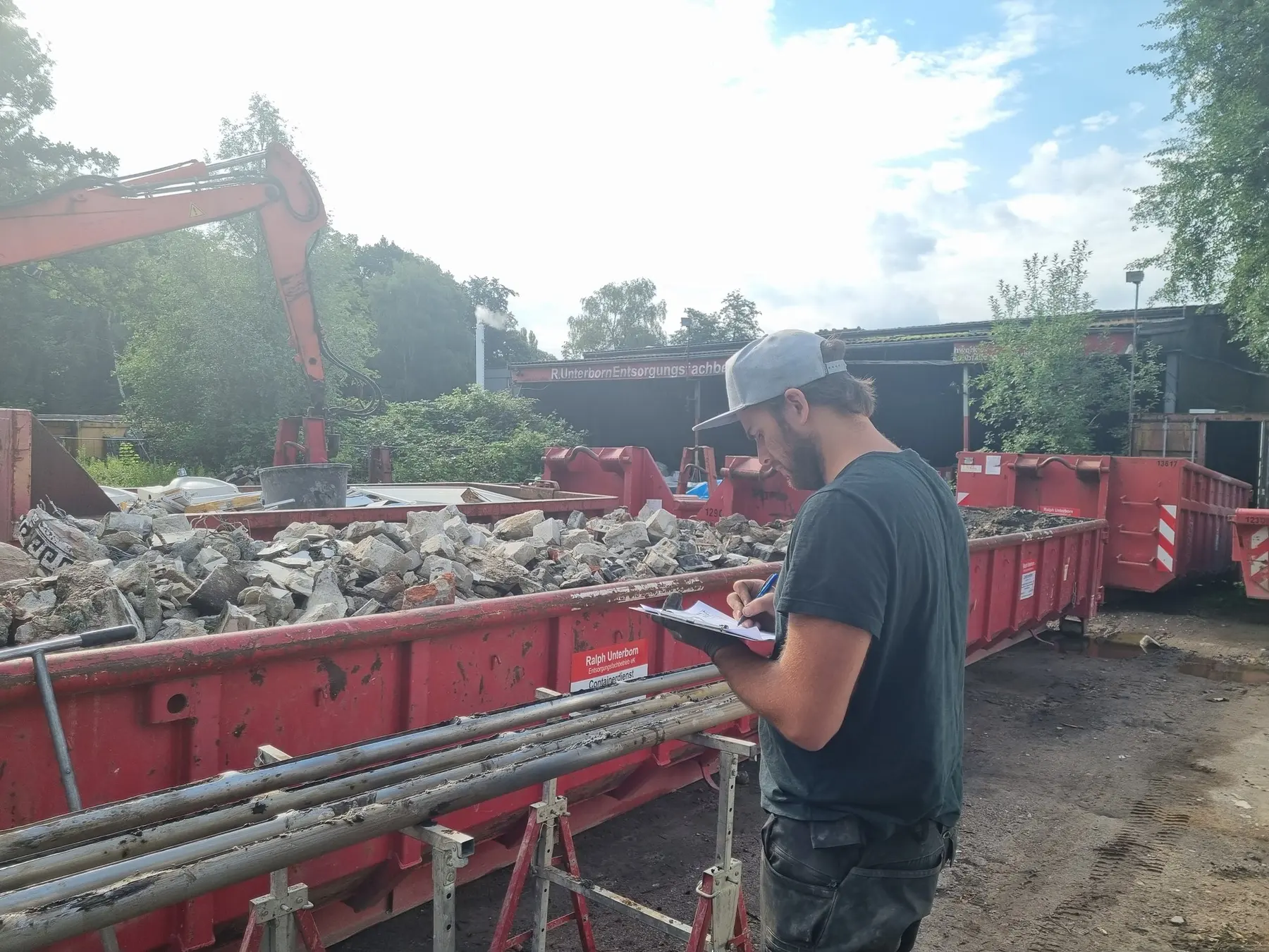 Mitarbeiter von Terra V dokumentiert eine Beprobung an Abfallcontainern im Freien